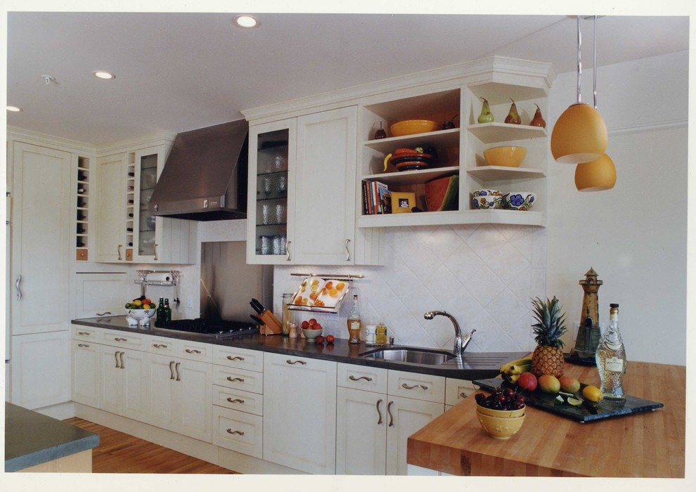 Mid-sized traditional galley kitchen in Auckland with a single-bowl sink, recessed-panel cabinets, white cabinets, concrete benchtops, white splashback, ceramic splashback, panelled appliances, medium hardwood floors, multiple islands, orange floor and grey benchtop.