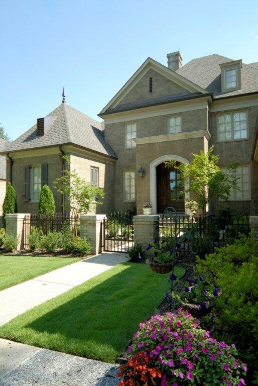 Large traditional front yard partial sun formal garden in Other with a garden path and concrete pavers for spring.