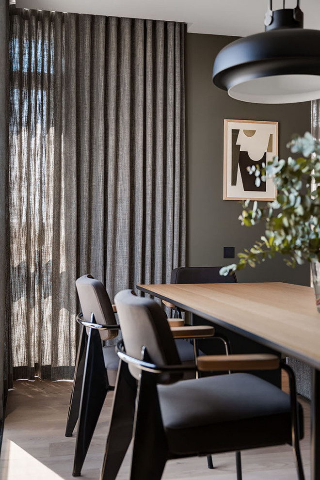 Idée de décoration pour une salle à manger ouverte sur la cuisine nordique de taille moyenne avec un mur gris, un sol en bois brun, un sol beige et boiseries.