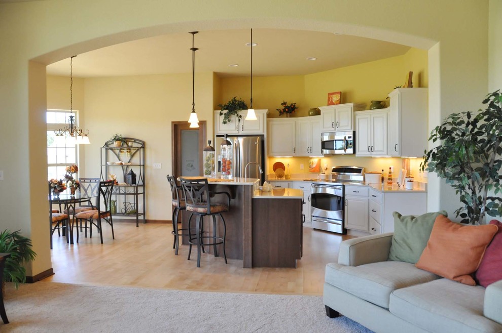 Inspiration for a mid-sized traditional l-shaped eat-in kitchen in Milwaukee with shaker cabinets, white cabinets, granite benchtops, stainless steel appliances, light hardwood floors and with island.
