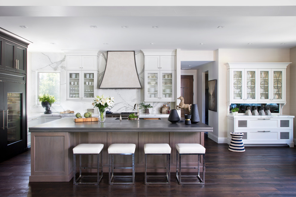 Inspiration for a transitional kitchen in Denver with glass-front cabinets, white cabinets, white splashback, panelled appliances, dark hardwood floors and with island.