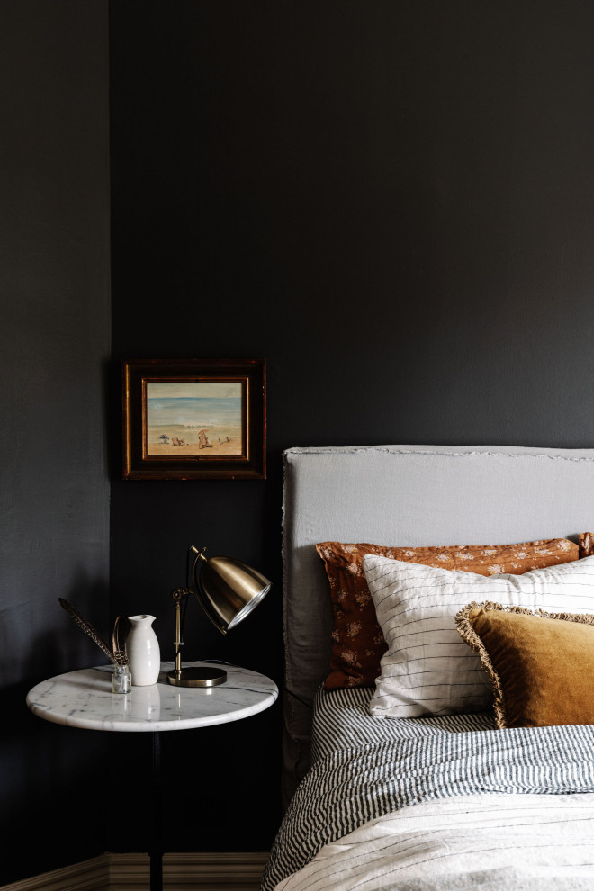 Inspiration for a mid-sized beach style master bedroom in Melbourne with black walls and brown floor.