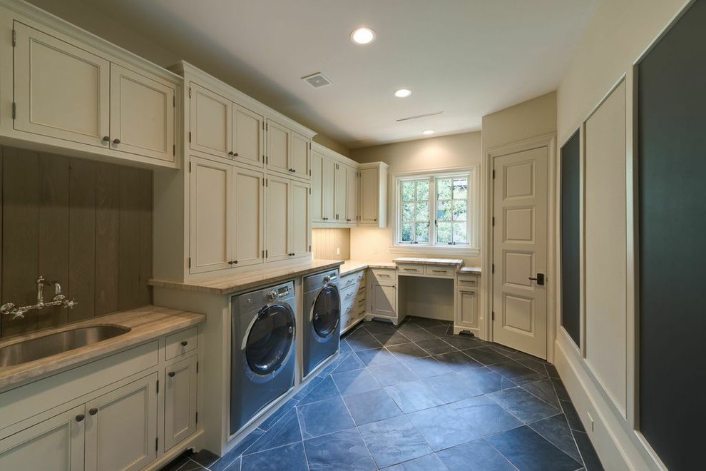 This is an example of a large traditional l-shaped utility room in Houston with an undermount sink, beige cabinets, beige walls, slate floors, a side-by-side washer and dryer and recessed-panel cabinets.