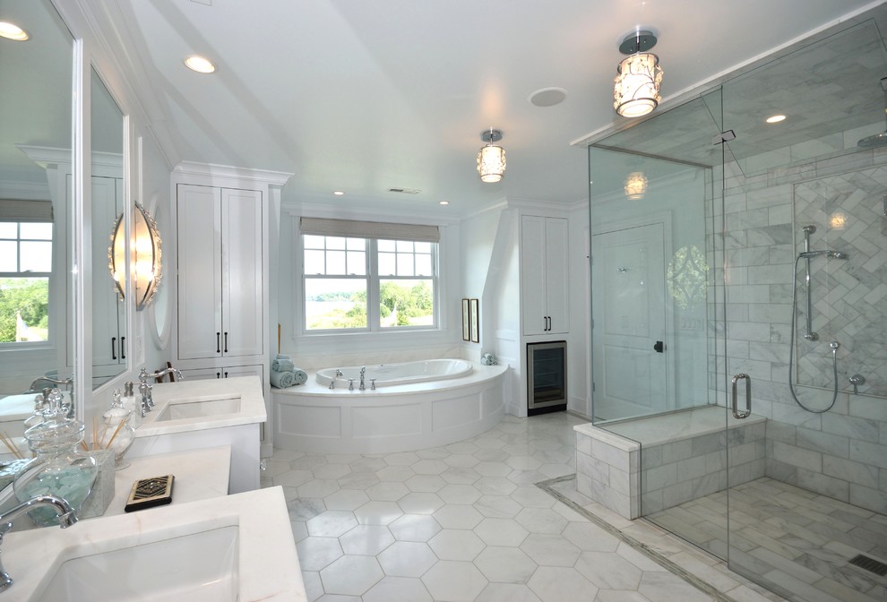 This is an example of a large traditional master bathroom in Bridgeport with shaker cabinets, white cabinets, an alcove tub, an alcove shower, a two-piece toilet, multi-coloured tile, stone tile, white walls, marble floors, an undermount sink, marble benchtops, white floor and a hinged shower door.
