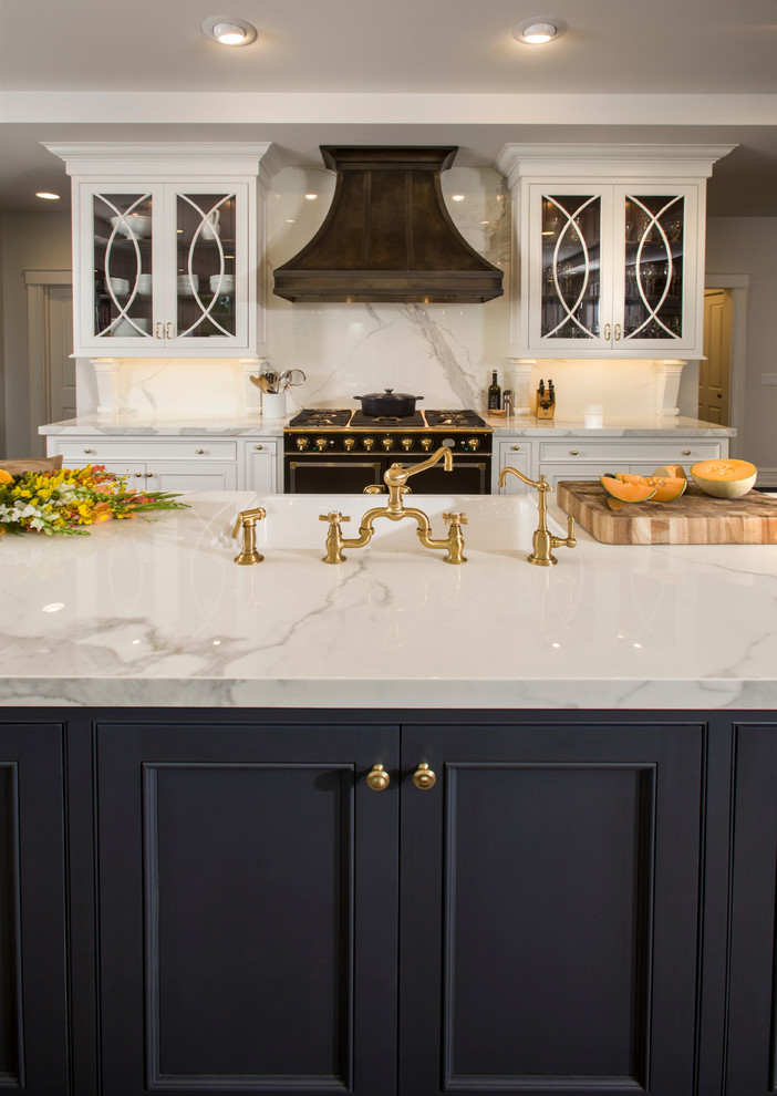 Photo of a large traditional l-shaped kitchen in Cincinnati with a farmhouse sink, glass-front cabinets, white cabinets, quartz benchtops, white splashback, stone slab splashback, panelled appliances, dark hardwood floors and multiple islands.