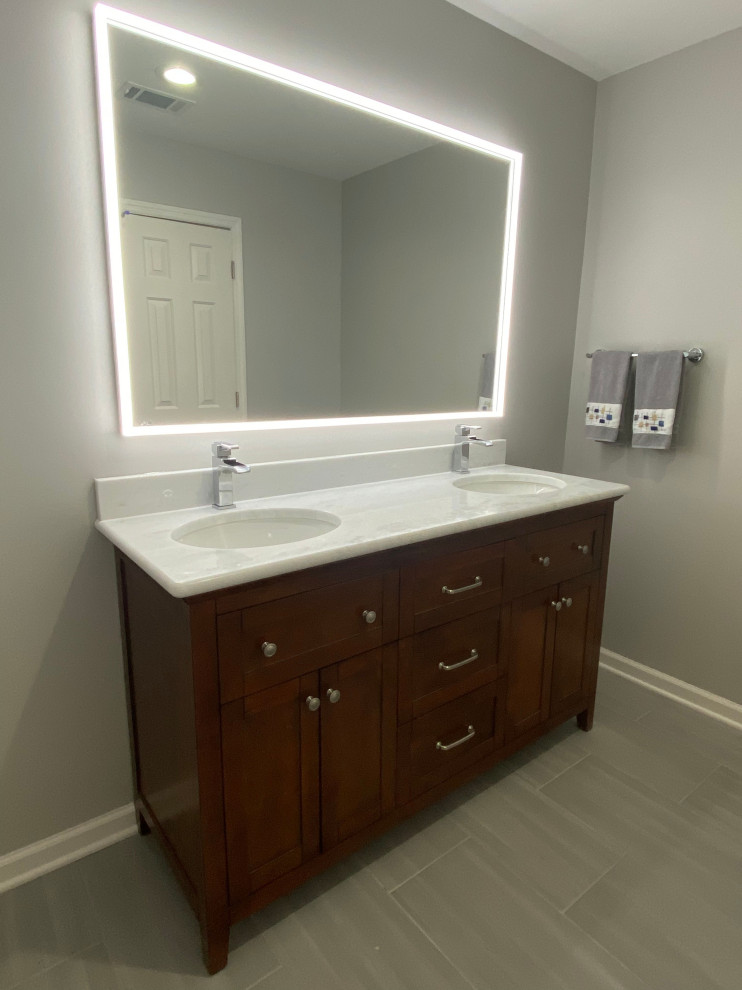 Mid-sized transitional master white tile porcelain tile, gray floor and double-sink alcove bathtub photo with recessed-panel cabinets, light wood cabinets, a two-piece toilet, an undermount sink, granite countertops, white countertops and a freestanding vanity