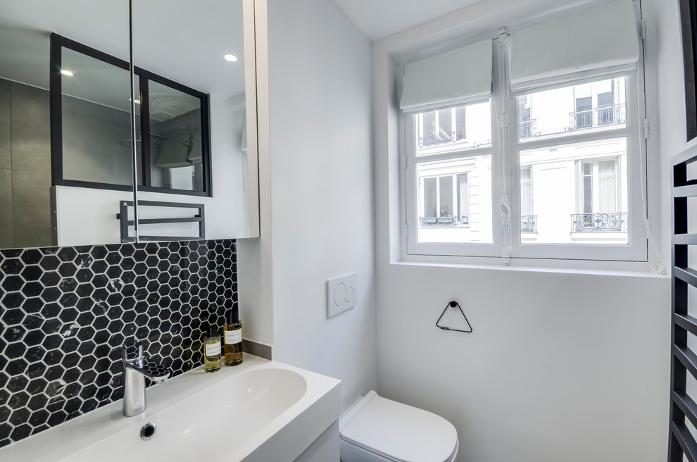 Inspiration for a small midcentury 3/4 bathroom in Paris with an open shower, a wall-mount toilet, black tile, marble, white walls, ceramic floors, a trough sink, grey floor, an open shower and white benchtops.