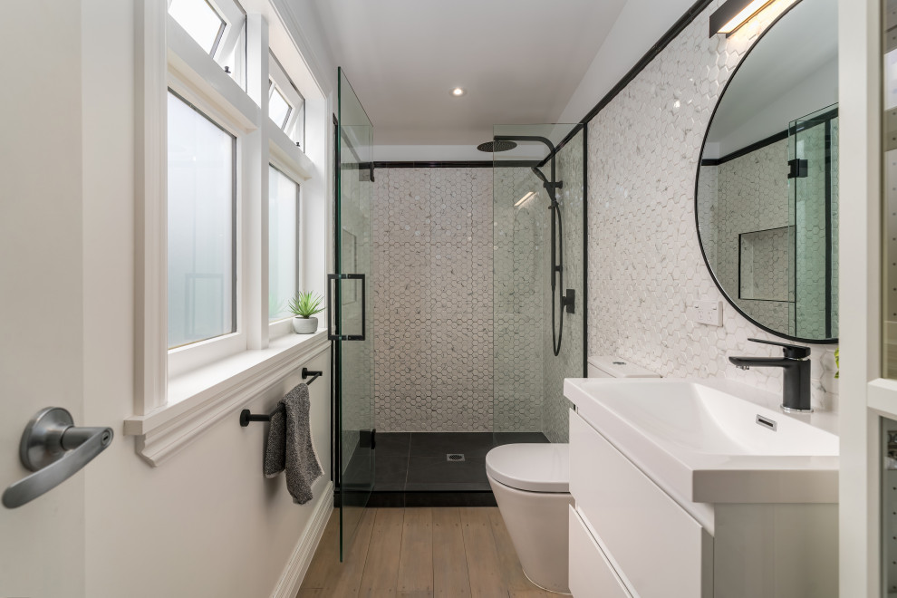 Idéer för att renovera ett mellanstort funkis badrum, med vita skåp, våtrum, vit kakel, gula väggar, laminatgolv, ett väggmonterat handfat, brunt golv och dusch med gångjärnsdörr