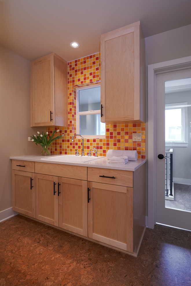 Design ideas for a mid-sized arts and crafts galley dedicated laundry room in Seattle with shaker cabinets, light wood cabinets, cork floors, quartz benchtops, a stacked washer and dryer, a drop-in sink, brown floor, grey walls and white benchtop.