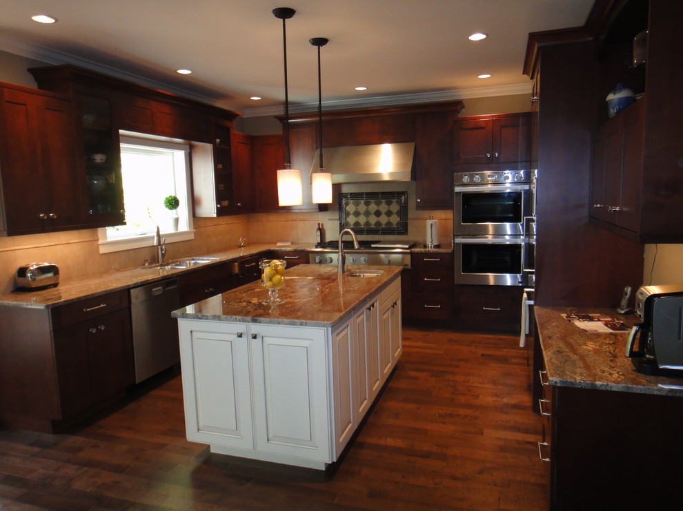 Inspiration for a large transitional u-shaped dark wood floor and brown floor enclosed kitchen remodel in Seattle with an undermount sink, shaker cabinets, dark wood cabinets, granite countertops, beige backsplash, ceramic backsplash, stainless steel appliances and an island