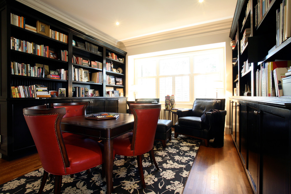 This is an example of a traditional family room in Vancouver with white walls, dark hardwood floors and a library.