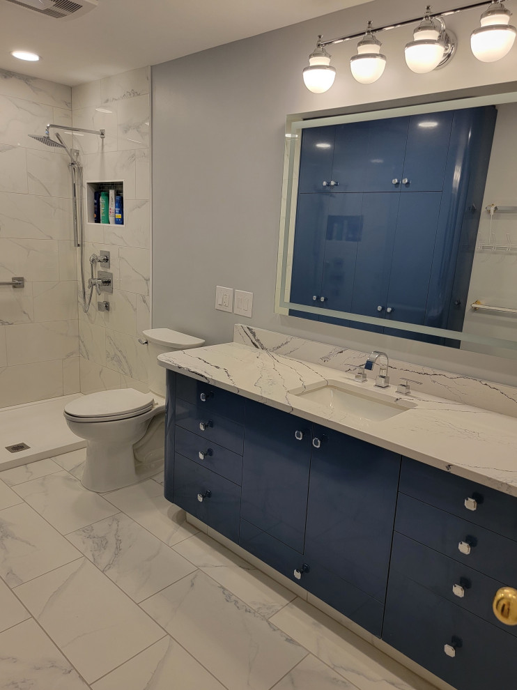 Photo of a mid-sized contemporary master bathroom in Other with flat-panel cabinets, blue cabinets, an open shower, a two-piece toilet, white tile, ceramic tile, grey walls, ceramic floors, an undermount sink, engineered quartz benchtops, white floor, a sliding shower screen, white benchtops, a single vanity and a built-in vanity.