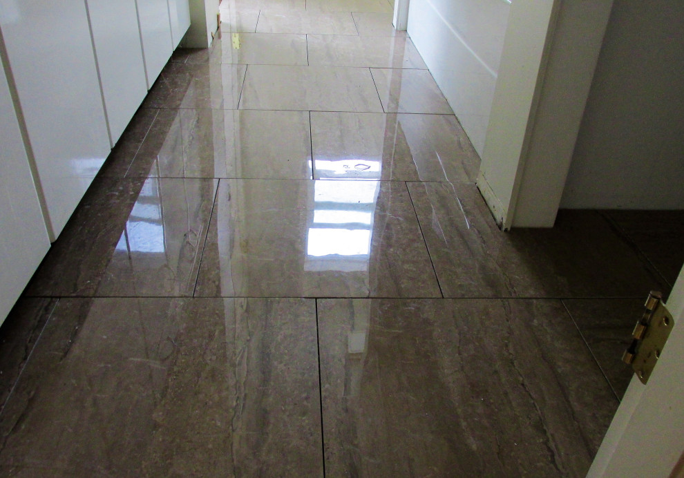 Example of a porcelain tile alcove bathtub design with granite countertops