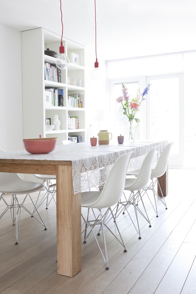 Inspiration for a modern dining room in Amsterdam with white walls and light hardwood floors.