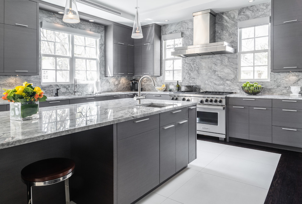 Photo of a contemporary l-shaped kitchen in New York with an undermount sink, flat-panel cabinets, grey cabinets, grey splashback, marble splashback, stainless steel appliances, with island and white floor.