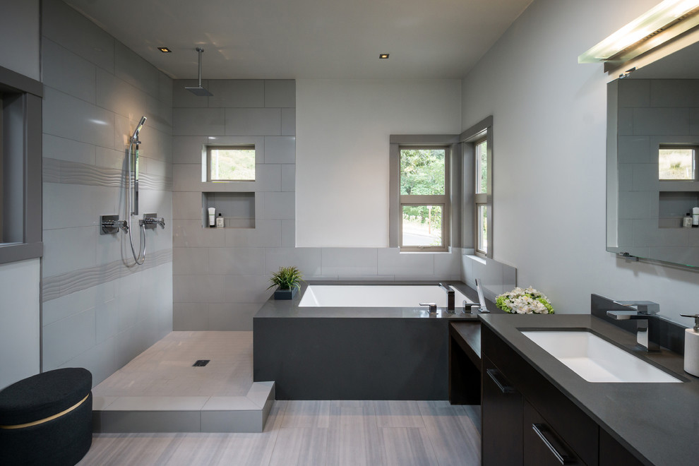 Mid-sized modern bathroom in Other with an undermount sink, flat-panel cabinets, dark wood cabinets, engineered quartz benchtops, a drop-in tub, a corner shower, gray tile, porcelain tile, grey walls and porcelain floors.