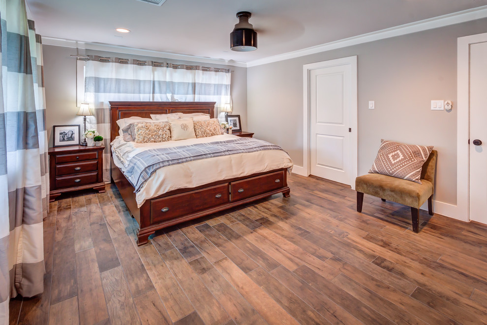 This is an example of a mid-sized transitional master bedroom in Houston with grey walls, porcelain floors and brown floor.