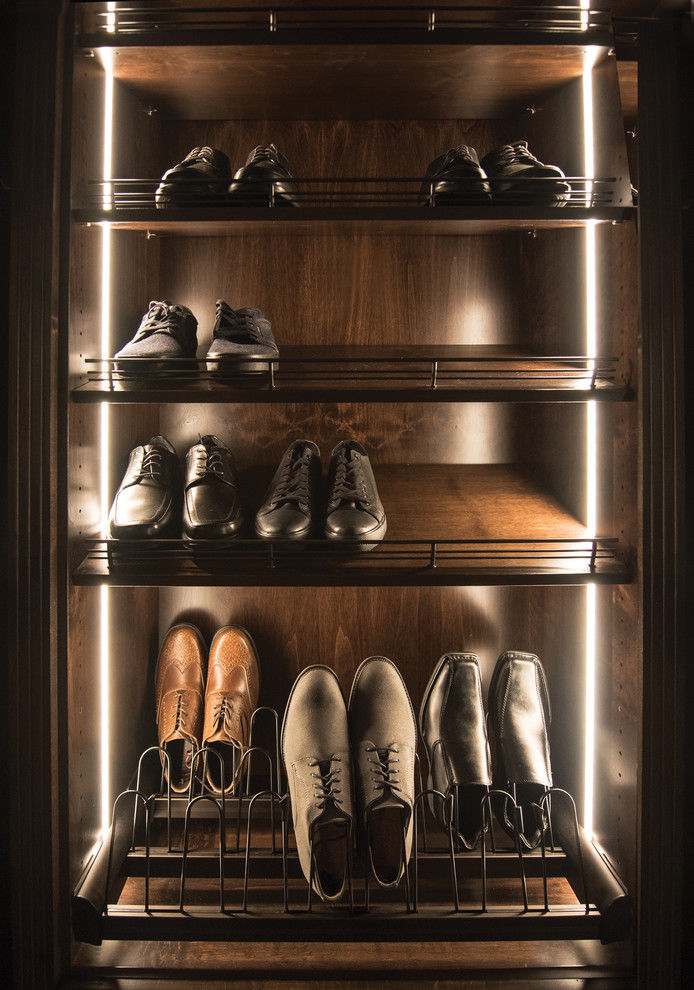 This is an example of a mid-sized modern men's walk-in wardrobe in Tampa with open cabinets, dark wood cabinets and carpet.