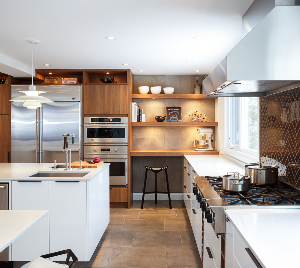 Photo of a contemporary open plan kitchen in Ottawa with black splashback, an undermount sink, flat-panel cabinets, white cabinets, quartz benchtops, subway tile splashback, stainless steel appliances, with island and grey floor.