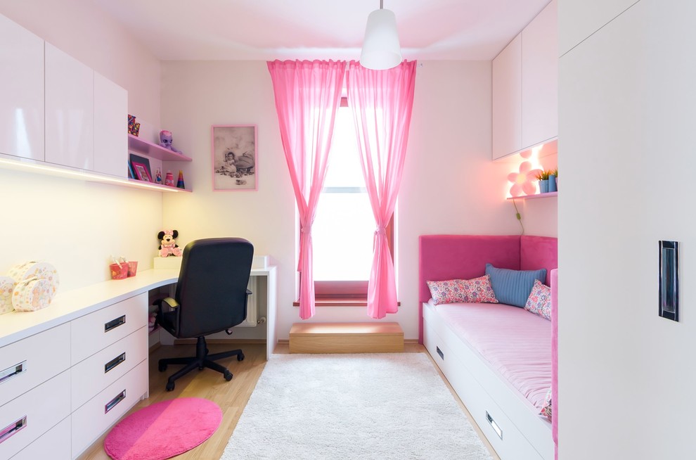 Photo of a contemporary kids' study room for kids 4-10 years old and girls with white walls and light hardwood floors.