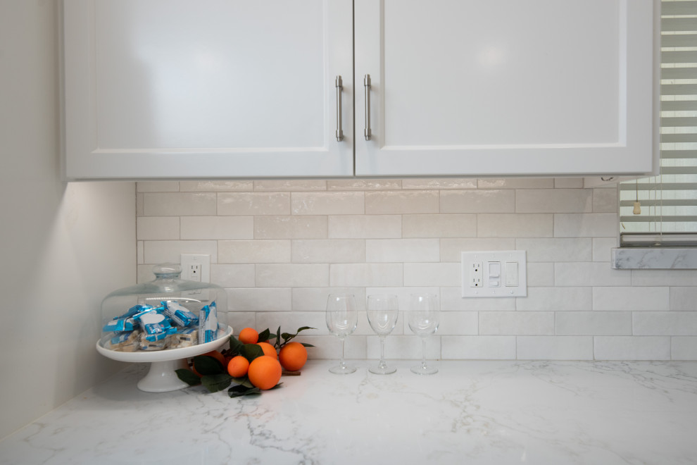 Inspiration for a modern eat-in kitchen in Sacramento with an undermount sink, shaker cabinets, white cabinets, quartz benchtops, white splashback, ceramic splashback, stainless steel appliances and grey benchtop.