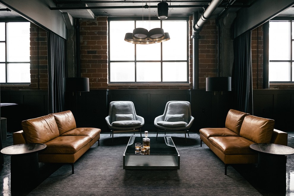 Urban concrete floor and black floor living room photo in Minneapolis with brown walls