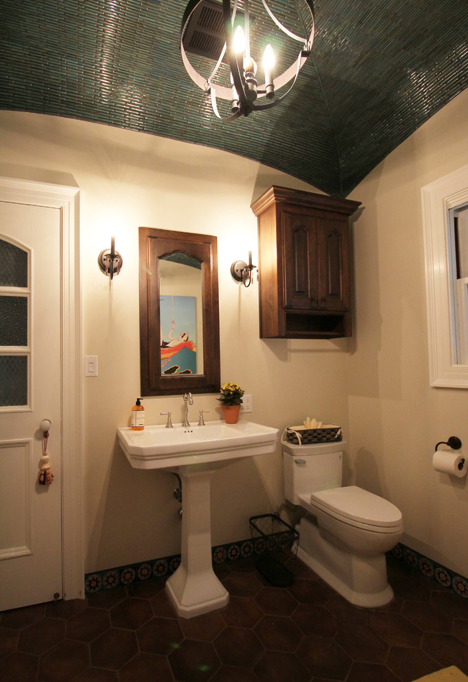 Photo of a mid-sized master bathroom in Sacramento with raised-panel cabinets, medium wood cabinets, a claw-foot tub, a two-piece toilet, multi-coloured tile, porcelain tile, beige walls, porcelain floors and a pedestal sink.