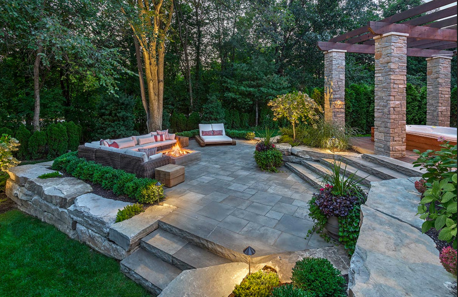 Traditional backyard patio in Orange County with a fire feature and natural stone pavers.