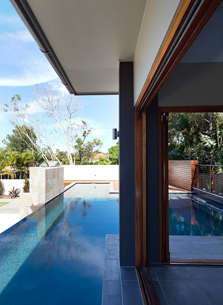 Contemporary custom-shaped pool in Brisbane with concrete pavers.