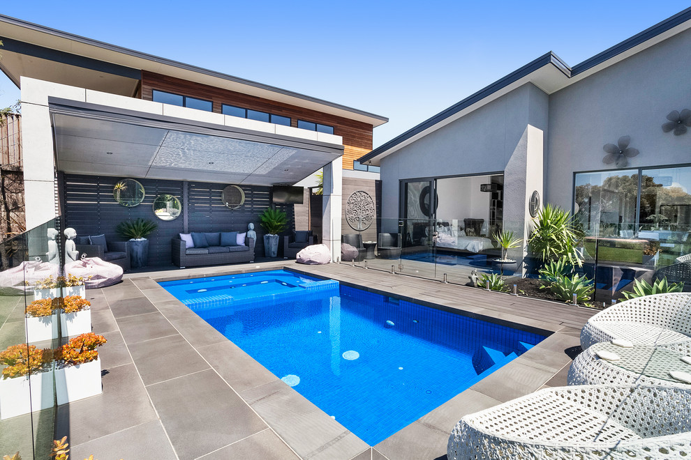 Contemporary backyard rectangular lap pool in Melbourne with a hot tub.