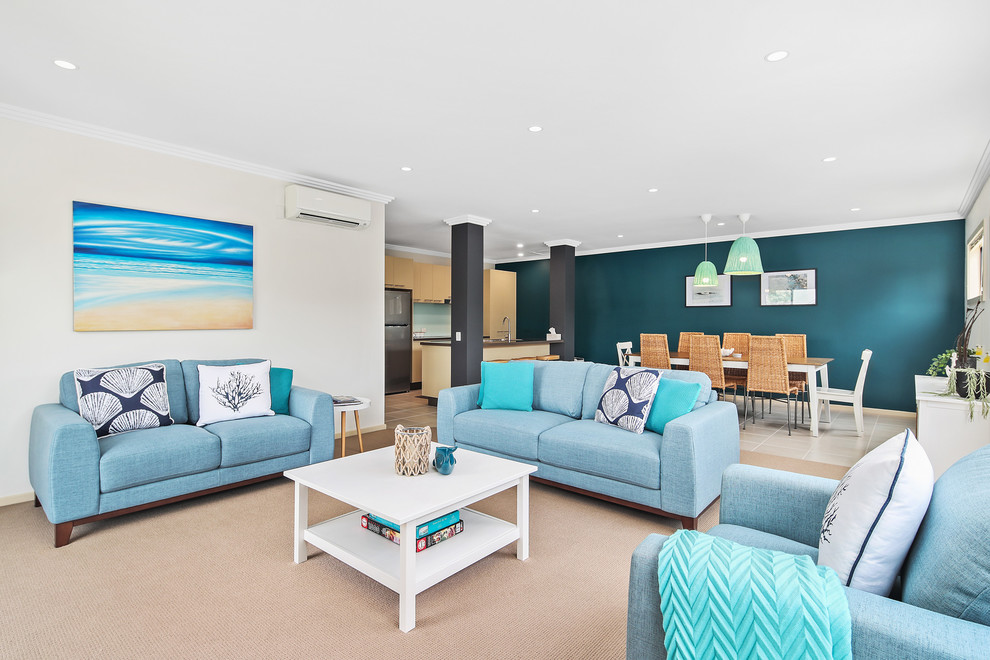 This is an example of a mid-sized beach style formal open concept living room in Melbourne with beige walls, no fireplace and beige floor.