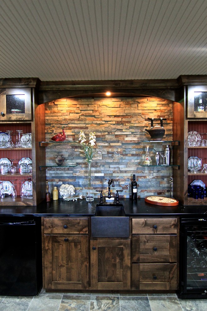 Mid-sized transitional seated home bar in Minneapolis with an undermount sink, shaker cabinets, dark wood cabinets, multi-coloured splashback, slate splashback, slate floors and brown floor.