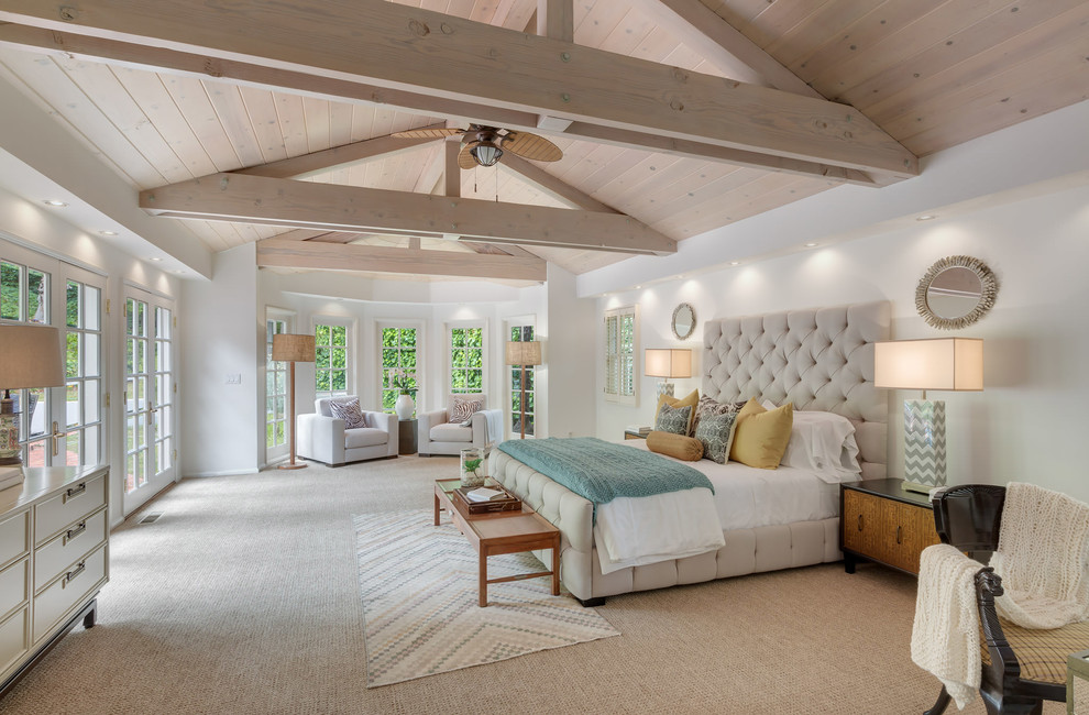 Large transitional master bedroom in Los Angeles with white walls, carpet and beige floor.