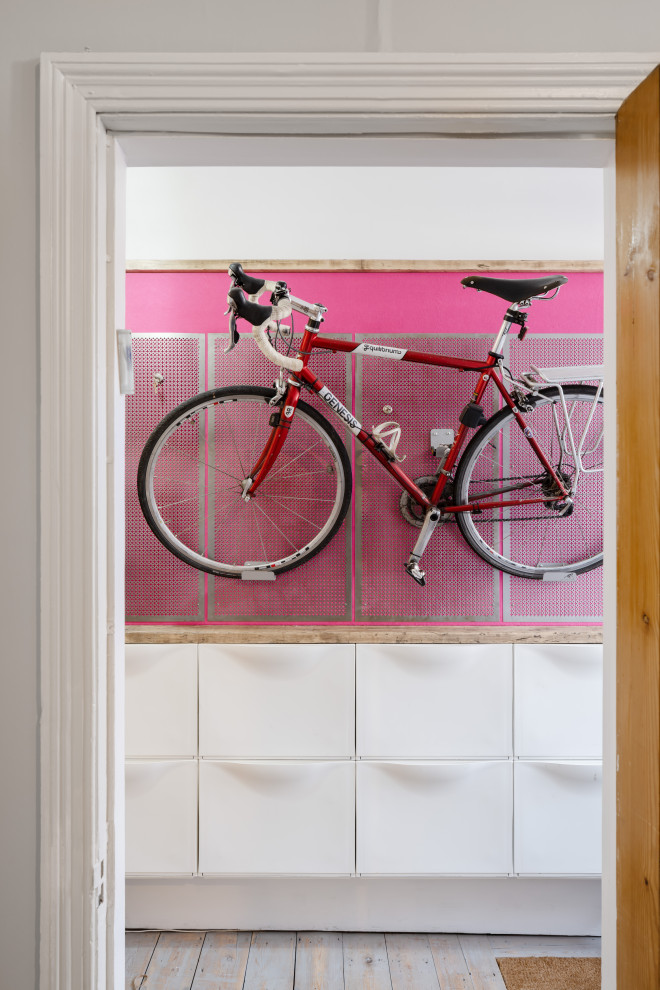 Modelo de recibidores y pasillos modernos pequeños con paredes rosas, suelo de madera clara, suelo gris y cuadros