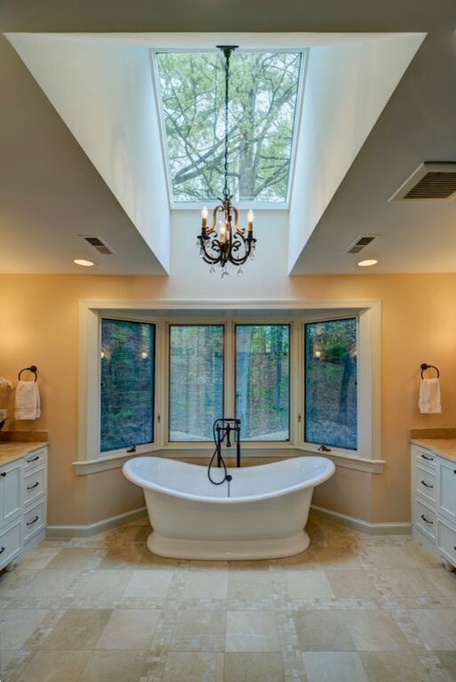Photo of a large modern master bathroom in DC Metro with a console sink, furniture-like cabinets, white cabinets, granite benchtops, a freestanding tub, a corner shower, beige tile, ceramic tile, beige walls and ceramic floors.