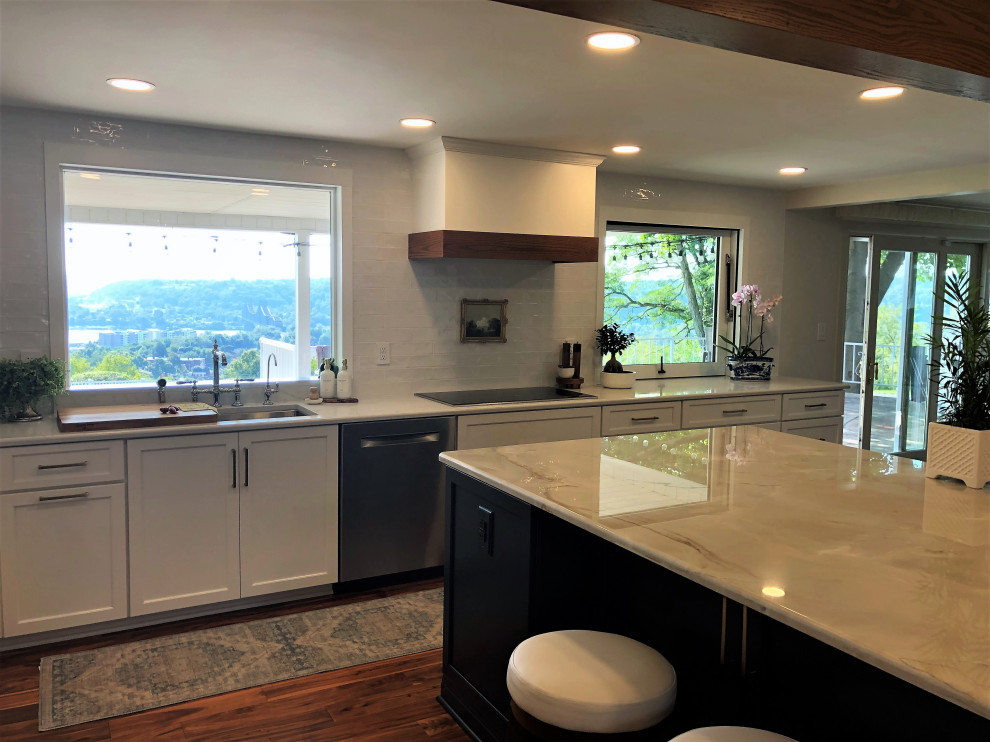 Mid-sized transitional l-shaped medium tone wood floor and brown floor kitchen pantry photo with an undermount sink, flat-panel cabinets, blue cabinets, quartz countertops, white backsplash, subway tile backsplash, stainless steel appliances, an island and gray countertops