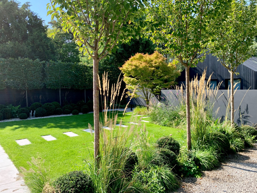 Foto di un giardino contemporaneo esposto in pieno sole di medie dimensioni e dietro casa in estate con pavimentazioni in pietra naturale e recinzione in legno