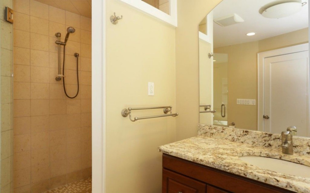 Inspiration for a mid-sized traditional master bathroom in New York with raised-panel cabinets, medium wood cabinets, a drop-in tub, a corner shower, a one-piece toilet, beige tile, marble, beige walls, marble floors, an undermount sink, marble benchtops, beige floor, a hinged shower door and multi-coloured benchtops.