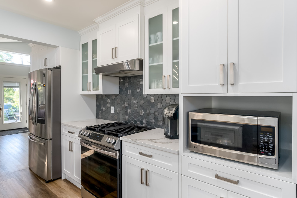 Inspiration for a transitional kitchen remodel in Edmonton with shaker cabinets, white cabinets, quartzite countertops, gray backsplash, cement tile backsplash, stainless steel appliances, an island and white countertops