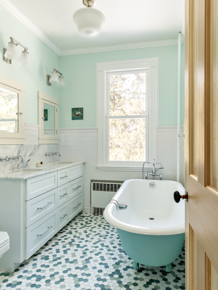 Photo of a mid-sized transitional master bathroom in New York with shaker cabinets, grey cabinets, a claw-foot tub, white tile, subway tile, blue walls, mosaic tile floors, an undermount sink, multi-coloured floor, white benchtops, an alcove shower, marble benchtops and a hinged shower door.