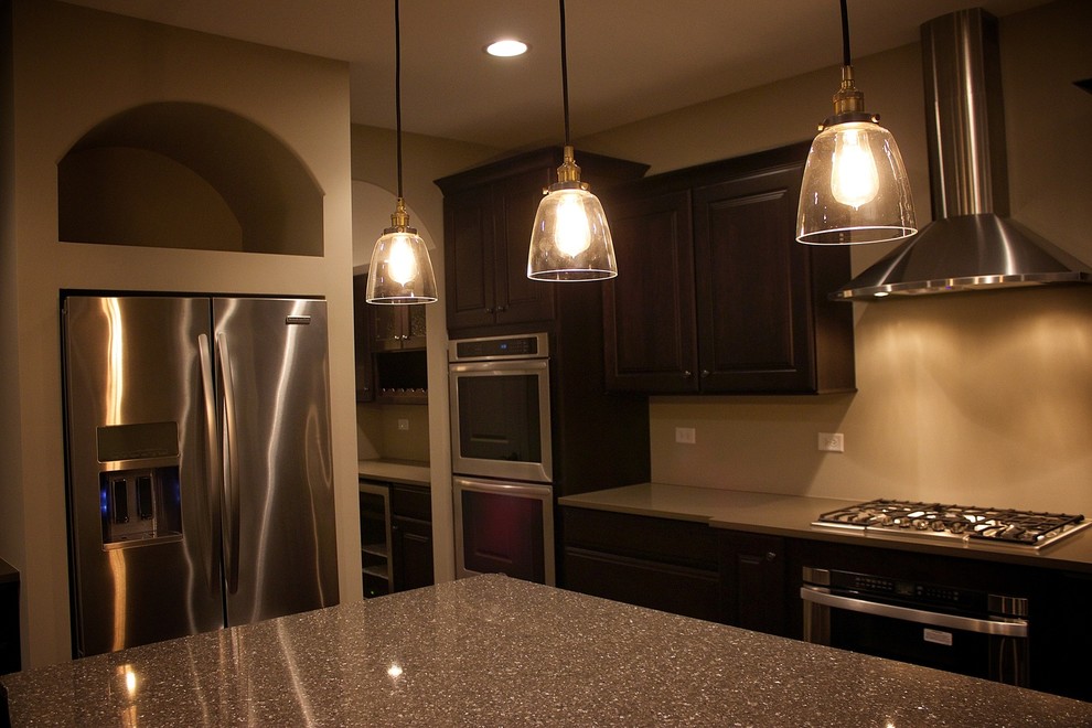 Enclosed kitchen - mid-sized transitional single-wall dark wood floor enclosed kitchen idea in Chicago with an undermount sink, recessed-panel cabinets, white cabinets, solid surface countertops, white backsplash, porcelain backsplash, stainless steel appliances and an island