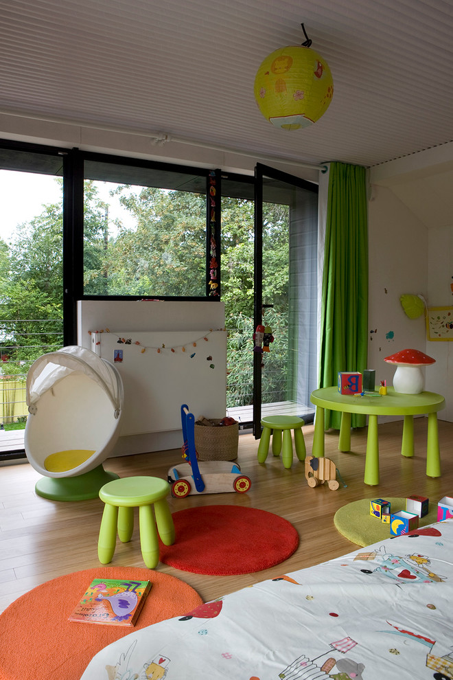 This is an example of a mid-sized contemporary gender-neutral kids' room in Paris with medium hardwood floors.