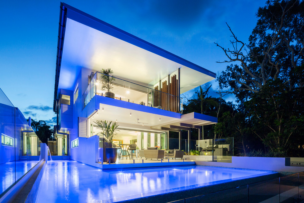 Mid-sized contemporary two-storey concrete white house exterior in Cairns with a flat roof and a metal roof.