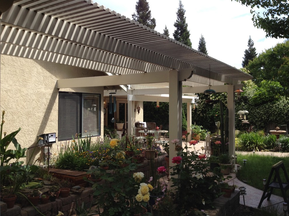 Photo of a large backyard patio in Sacramento with concrete pavers and a pergola.