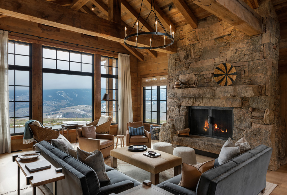 Inspiration for a large rustic living room in Other with light hardwood flooring, a standard fireplace, a stone fireplace surround, no tv, brown floors, exposed beams and wood walls.
