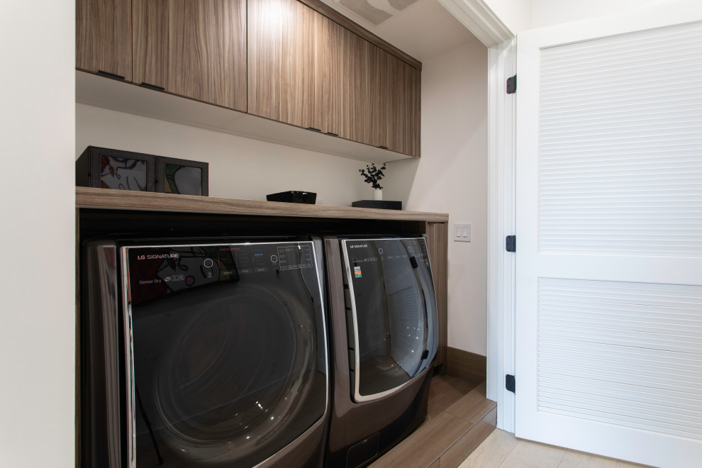 Inspiration for a small contemporary galley dedicated laundry room in Los Angeles with flat-panel cabinets, brown cabinets, laminate benchtops, white walls, porcelain floors, a side-by-side washer and dryer and brown benchtop.