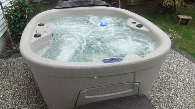 Backyard gravel and round aboveground hot tub photo