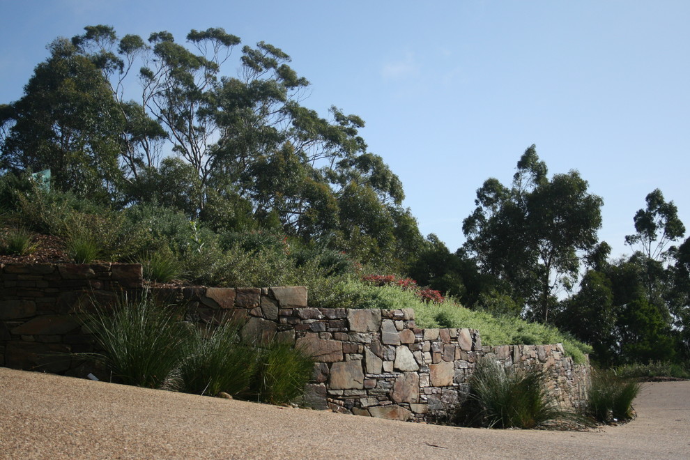 Photo of a large country sloped full sun xeriscape in Geelong with a retaining wall and natural stone pavers.