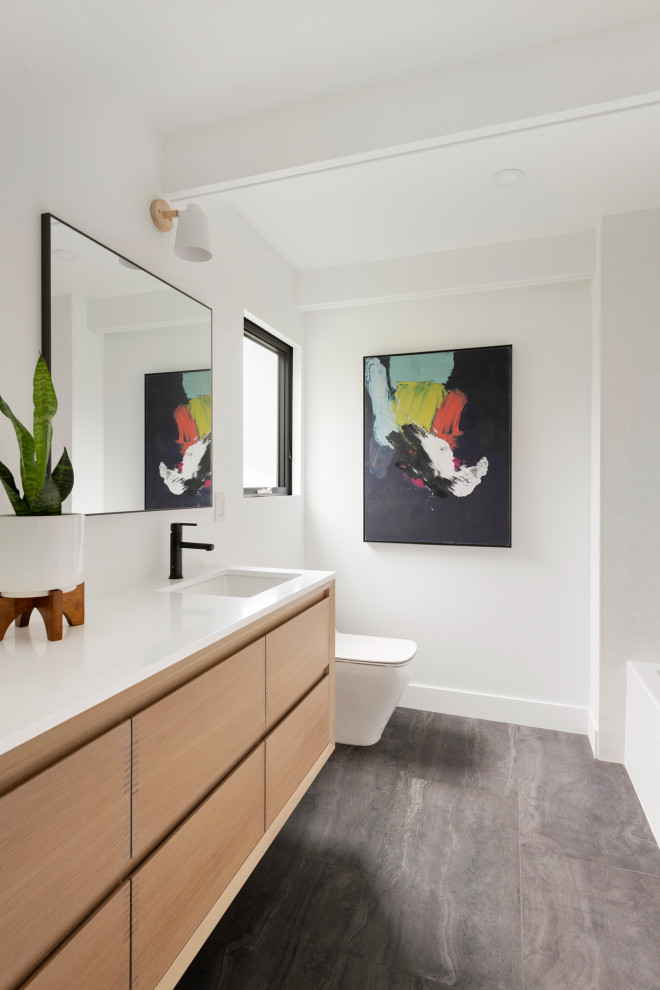 ミネアポリスにあるミッドセンチュリースタイルのおしゃれな浴室 (黒いタイル、スレートタイル、珪岩の洗面台、白い洗面カウンター、洗面台2つ) の写真