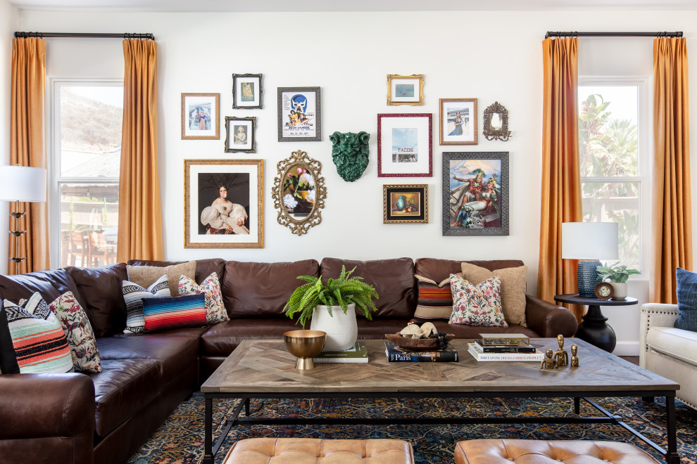 Design ideas for a large eclectic open concept living room in San Diego with white walls, terra-cotta floors, a standard fireplace, a tile fireplace surround and a wall-mounted tv.